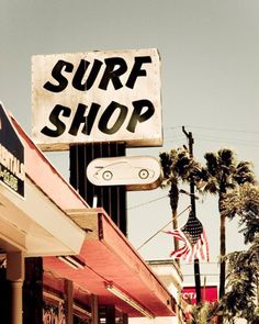 a black and white photo of a surf shop sign