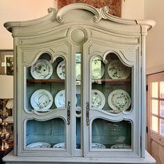 an old china cabinet with plates on it