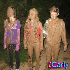 three people covered in mud standing next to each other