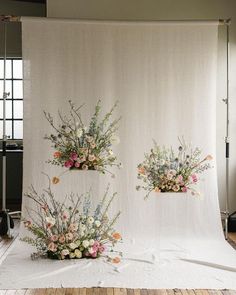 two vases with flowers on a white backdrop