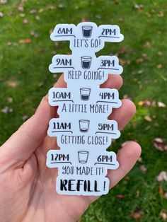 a person holding up a white sticker with different times and drinks on it in their hand