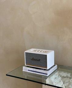 a white radio sitting on top of a glass table