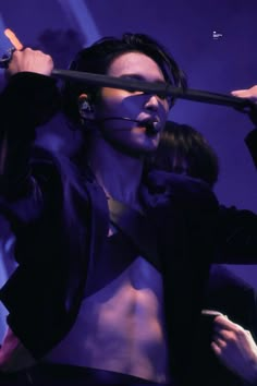 a man with no shirt on holding a microphone