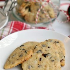 two cookies on a white plate with red and white checkered table cloth