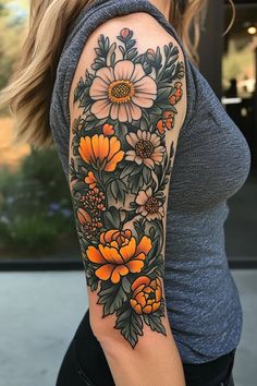 a woman's arm with an orange and white flower tattoo on it, in front of a building