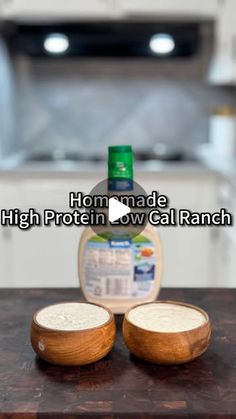 two wooden bowls sitting on top of a counter next to a bottle of milk and an oven in the background