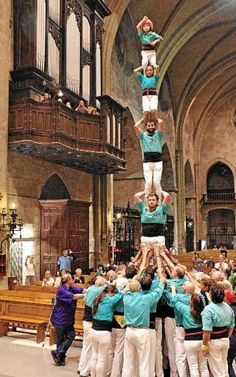 a group of people standing on top of each other in front of a church pew