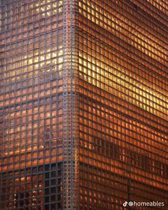 the top of a tall building with lots of glass covering it's face and sides