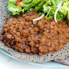 a blue plate topped with lettuce and beans