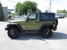 a green jeep parked in a parking lot