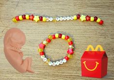 red and yellow bracelets that say "McFetus". Aka fetus brand deal with McDonald's. Therian Bracelet Ideas, Kandi Bead Bracelets, Matching Kandi Bracelet Ideas, Mcr Kandi Bracelets, Mario Kart Kandi Cuff, Matching Kandi Bracelets, Gir Bracelet Kandi, Gir Kandi Cuff, Domo Kandi Cuff