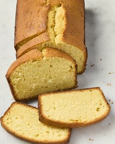 sliced loaf of pound cake sitting on top of a white counter next to slices cut from it