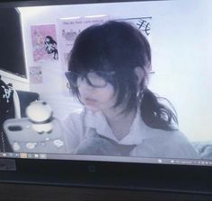 a woman with glasses is looking at a computer screen