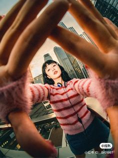 a woman making a heart shape with her hands