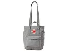 Fjallraven Kanken Totepack - Tote Handbags : Fog : The Fj&,#228,llr&,#228,ven K&,#229,nken Totepack is functional and versatile enough to take anywhere, transforming from a tote, to a backpack with ease when changing commute options or walking around the supermarket. Waterproof G-1000 HeavyDuty Eco S fabrication keeps your stuff dry all-day long. Main compartment can hold all your daily essentials. Interior lined with a padded base for tablets. Zippered top main compartment opening. Front zipper Casual Backpack With Top Carry Handle, Casual Daily Use Backpack With Top Carry Handle, Fjallraven Kanken Totepack, Kanken Totepack, Fjallraven Totepack, What In My Bag, Zipper Top, Daily Essentials, Fjallraven Kanken