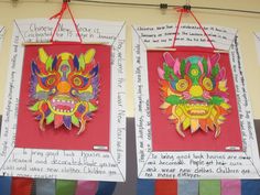 two colorful paper masks hanging from strings on the wall in front of a bulletin board