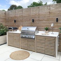 an outdoor kitchen with grill and seating area