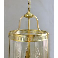 an antique brass hanging light fixture with clear glass