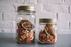 two glass jars filled with nuts and oranges