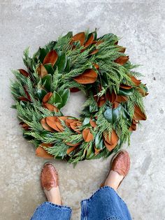 a person standing next to a wreath on the ground