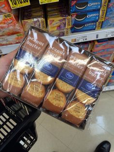 a person is holding up some cookies in their hand at the grocery store and it looks like they are going to eat them