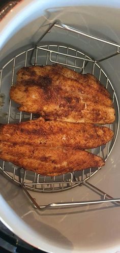 two pieces of fried fish sitting on top of a frying pan in an oven