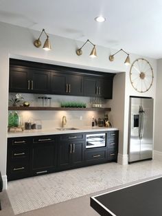 a kitchen with black cabinets and gold accents