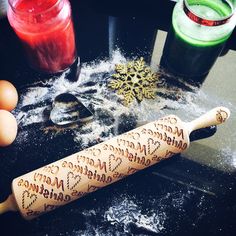 a wooden rolling pin sitting on top of a table next to eggs and other ingredients