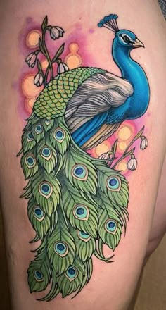 a peacock tattoo on the back of a woman's thigh