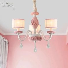 a chandelier hanging from the ceiling in a pink room