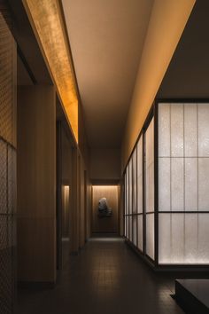 an empty hallway with lots of windows and lights on either side of the room,