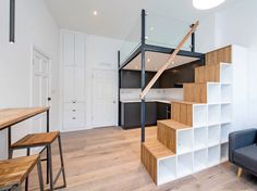 a living room filled with furniture and a stair case in front of a couch next to a table