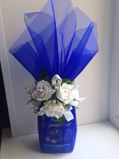 a blue vase filled with white flowers on top of a table