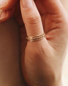 a woman's hand with a gold ring on it