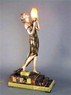 a statue holding a lit candle on top of a book