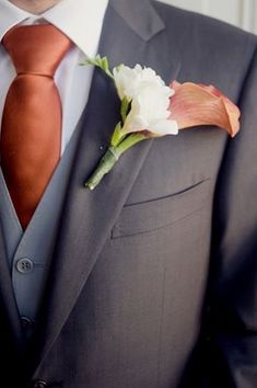 a man in a suit with a flower on his lapel