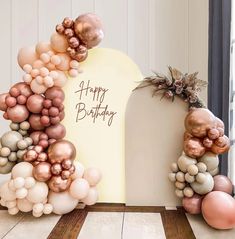 an arch made out of balloons with the words happy birthday written in gold and pink