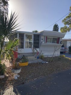 a mobile home is parked on the side of the road in front of some plants