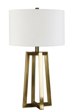 a table lamp with a white shade on the top and gold metal frame around it