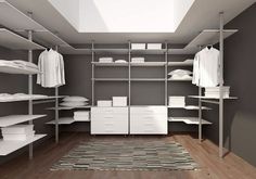 an empty walk - in closet with clothes on the shelves and drawers, along with a rug