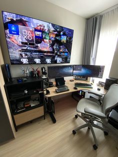 a computer desk with two monitors and a keyboard on it in front of a window