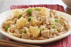 a white plate topped with rice and meat next to chopsticks