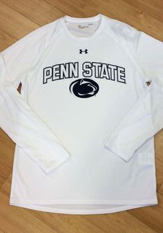 a white penn state long sleeve t - shirt sitting on top of a wooden floor