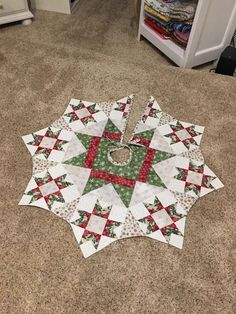 a quilted table topper sitting on the floor in front of a bookcase