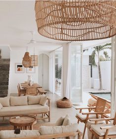 a living room filled with lots of furniture next to a swimming pool and palm trees