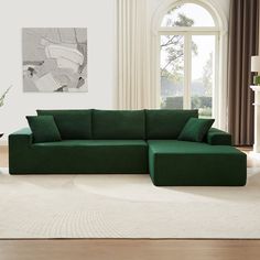 a living room with a large green couch in the center and a white rug on the floor