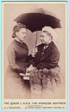 an old black and white photo of two women under an umbrella, one holding the other's hand