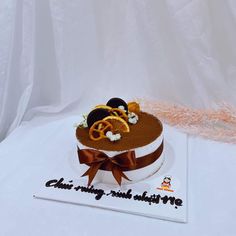 a cake that has been decorated with oranges and blackberries on top is sitting on a white tablecloth