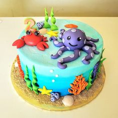 there is a blue cake with an octopus and sea animals on the top, along with other decorations