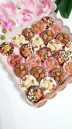 a tray filled with lots of different types of cookies on top of a white table